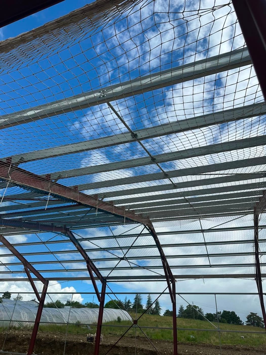Filet de sécurité sur grande charpente métallique avec nacelle sur site