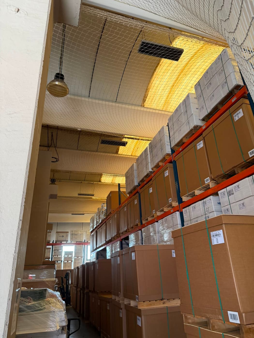 Filet de sécurité sous toiture d'un entrepôt de stockage avec racks