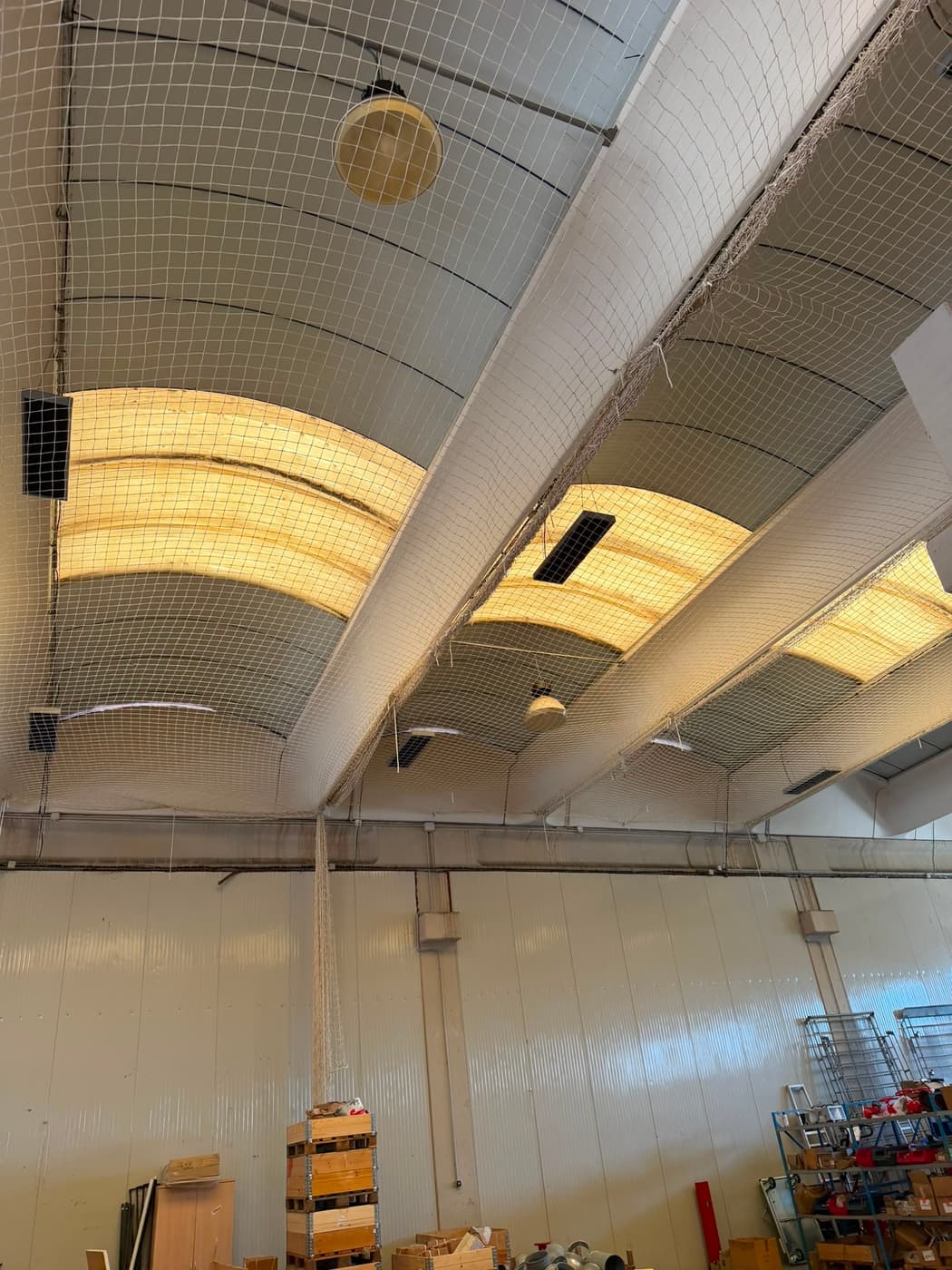Filet en nappe sous la toiture d'un bâtiment industriel éclairé
